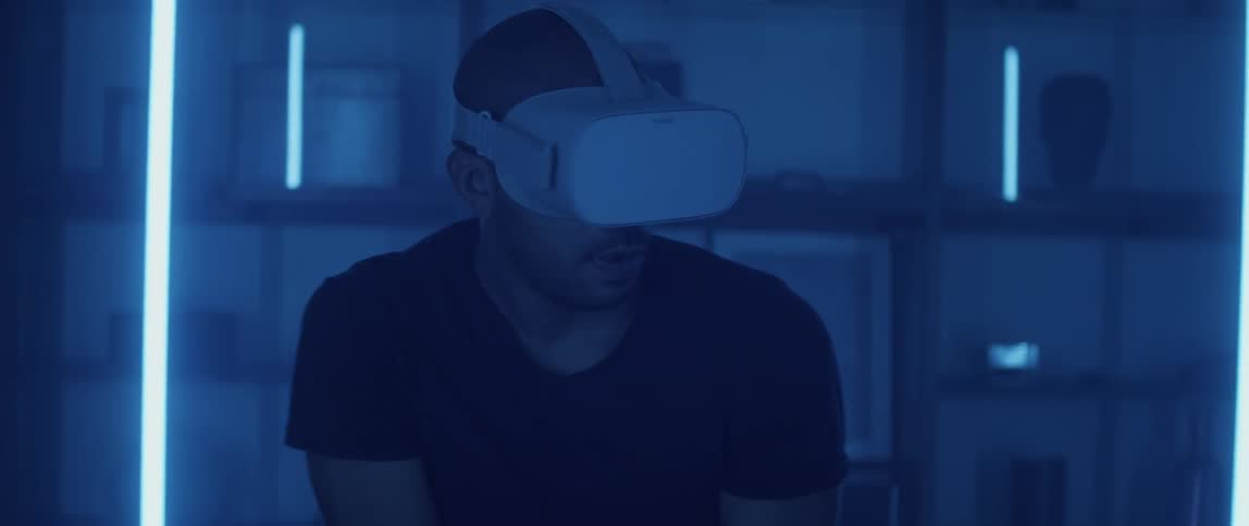 A man makes gun firing motions while playing a game on a virtual reality headset