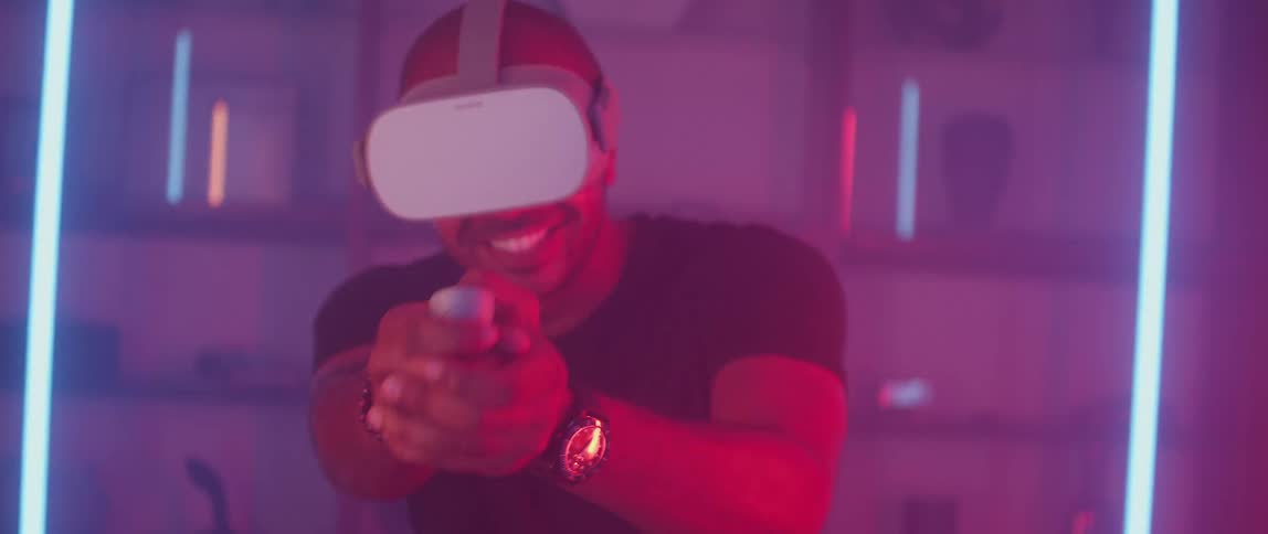 Man at home wearing a virtual reality headset playing first person shooter video games at home