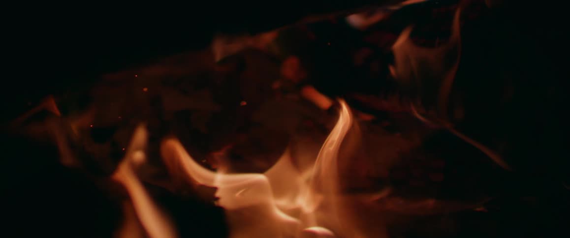 Flames can be seen as they slowly burn and object in the darkness