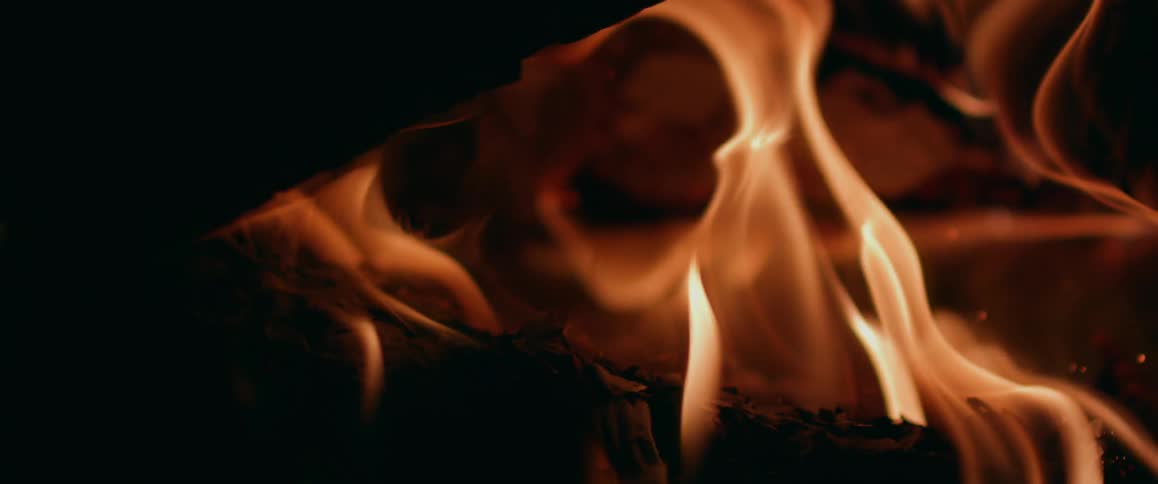 Flames consuming wood burn pale orange