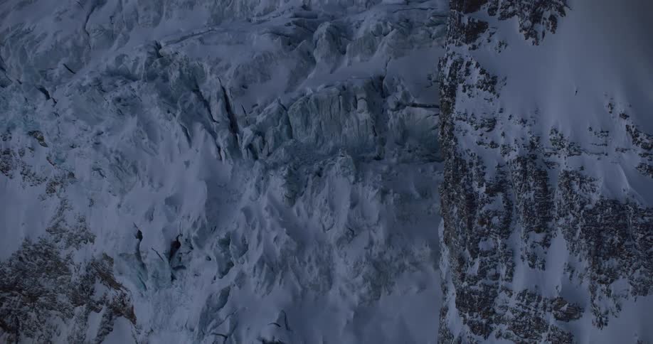 An aerial view of a snowy mountain range in the wilderness