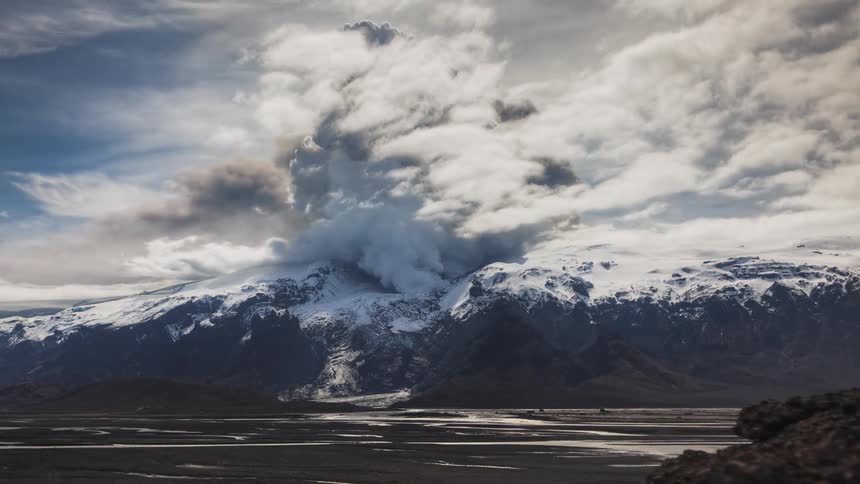A time lapse of clouds moving over a volcano mountain range by a lake Eyjafjallajökull, Iceland
