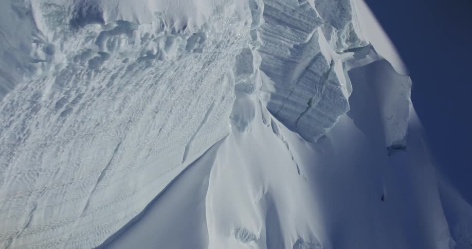 Aerial view of snowy mountain against the blue sky