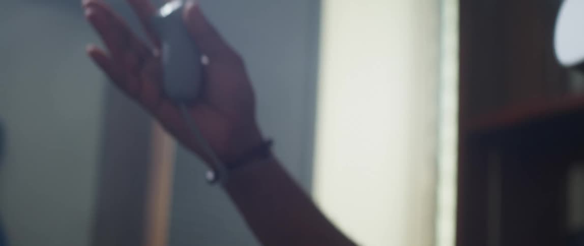 Man equipped with virtual reality headset and controller plays video game in the living room