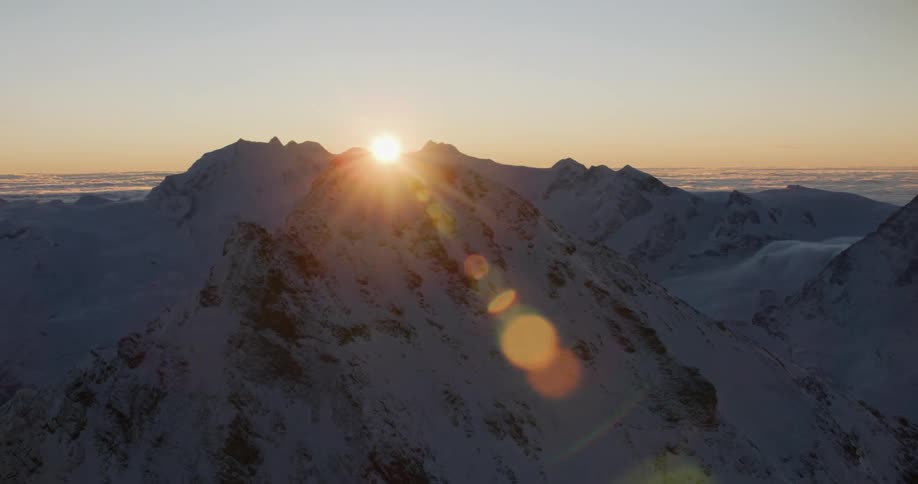 Aerial view of snowy mountain range at sunset