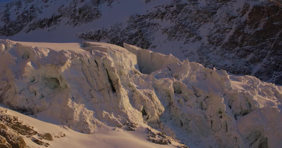 An aerial view of a snowy mountain range in the wilderness