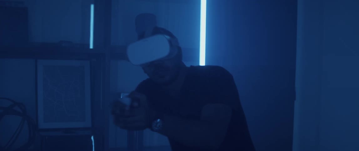 A man is playing a virtual reality game in the dark