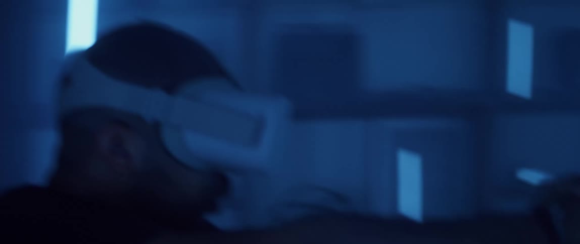 Man wearing a virtual reality headset playing first person shooter video games at home