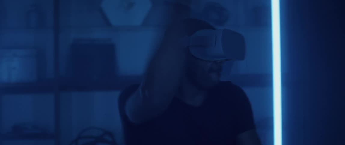 A man playing a video game with a virtual reality headset in a living room