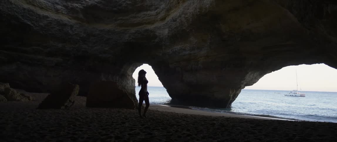 Woman standing in a cavernous area of a beach