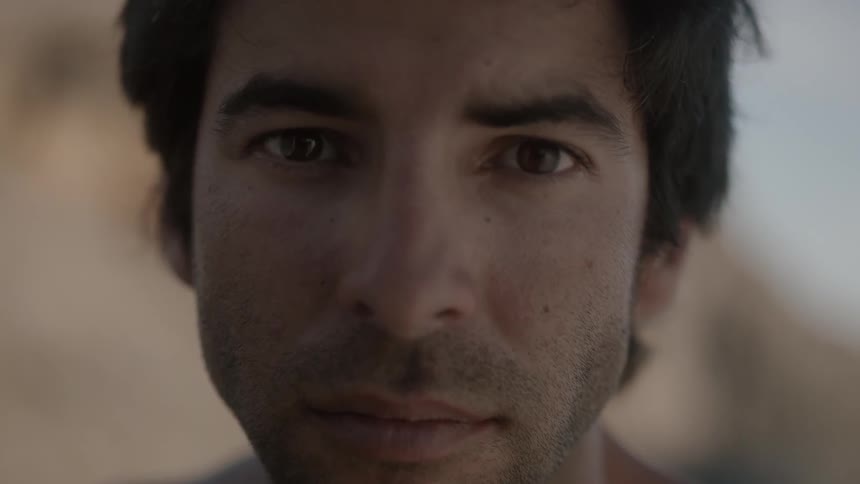 Close-up of shirtless man looking into camera