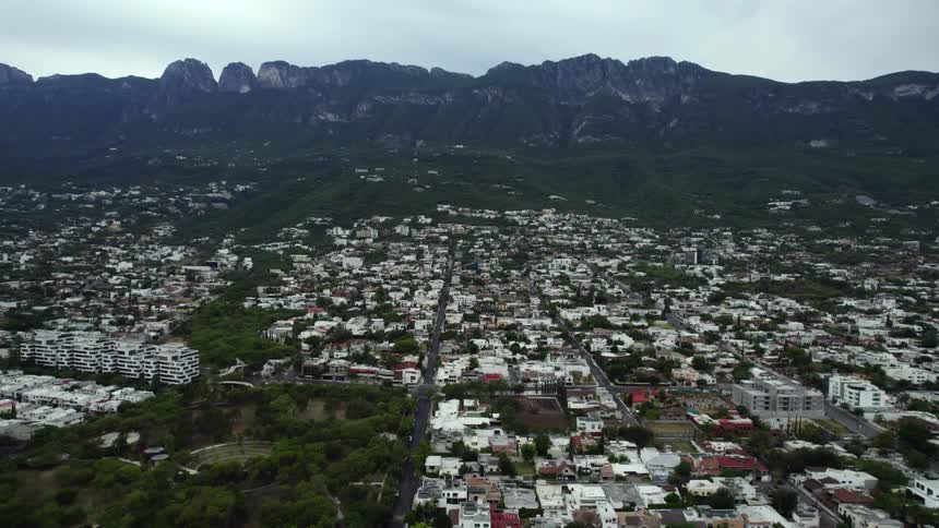 A large city sprawls at the foot of a mountain range