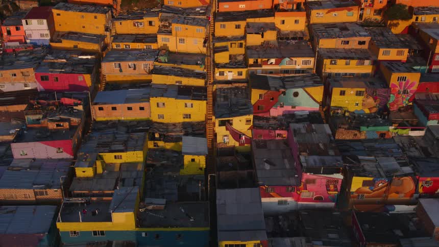 Aerial view of colorful favelas on a hill or mountain at evening