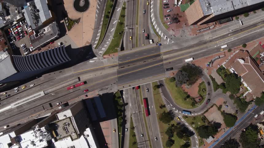 An aerial view of shipping trucks taxis and person vehicles driving in a city