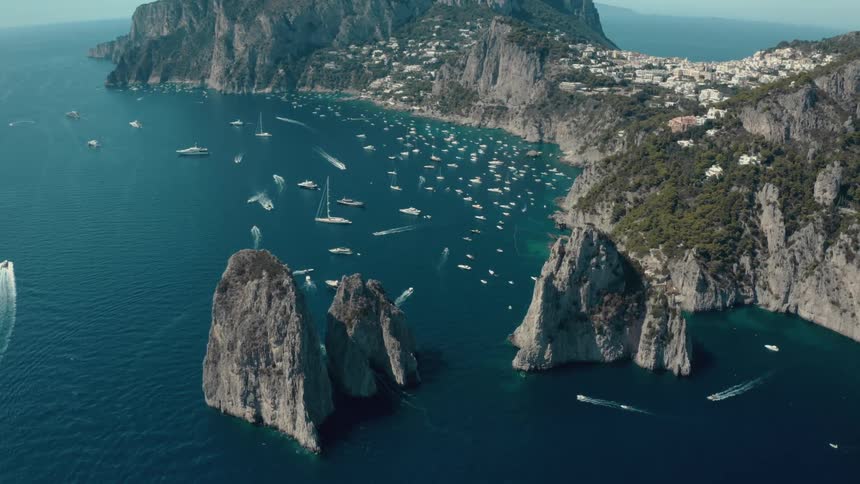 Aerial view of boats in front of a coastal town on an island in the ocean