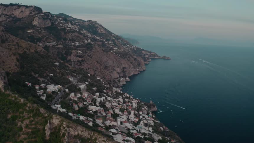 A village is on the side of a mountain with a lake at the bottom