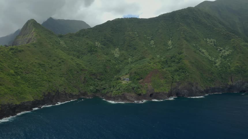 Aerial top down view of the rugged coast where mountains meet the ocean at daytime