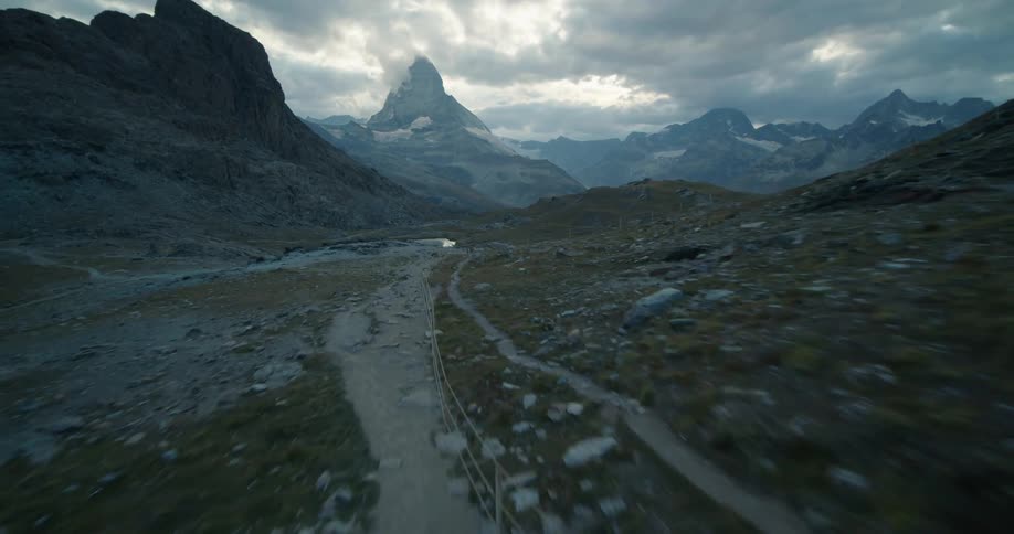 A trail in a mountain range leading to a river