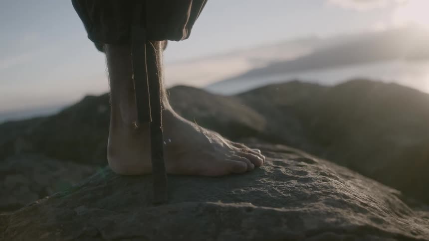Strings hang from the pants of someone standing atop a mountain
