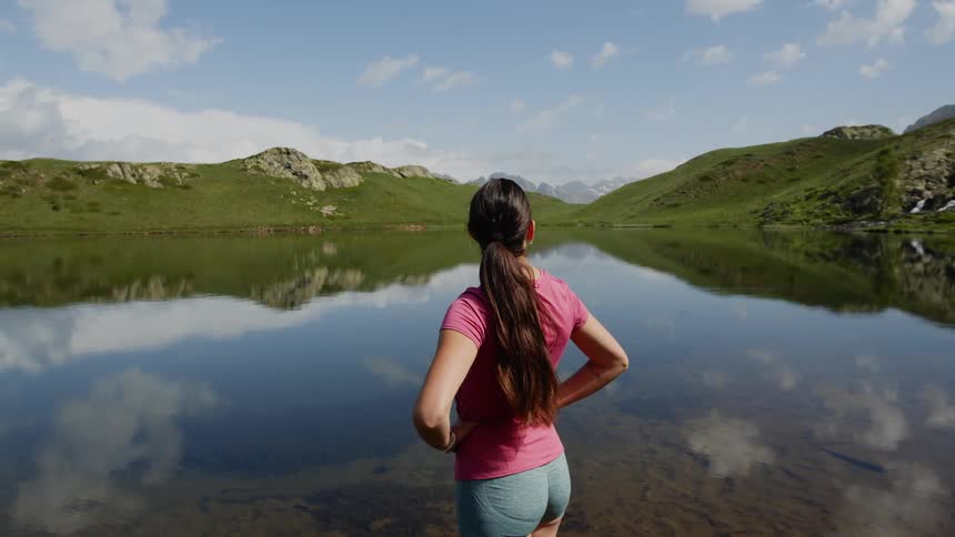 A woman is standing outdoors near a body of water