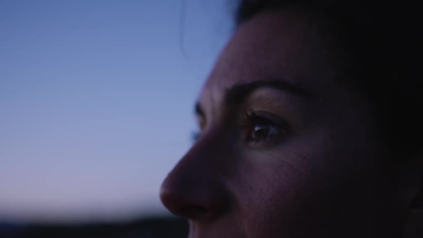 Close up of the eyes of a woman looking at the horizon at evening