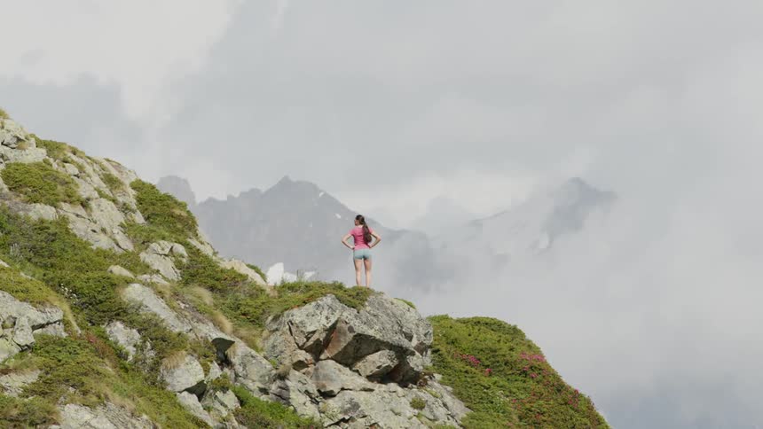 A woman is hiking up a mountain during spring