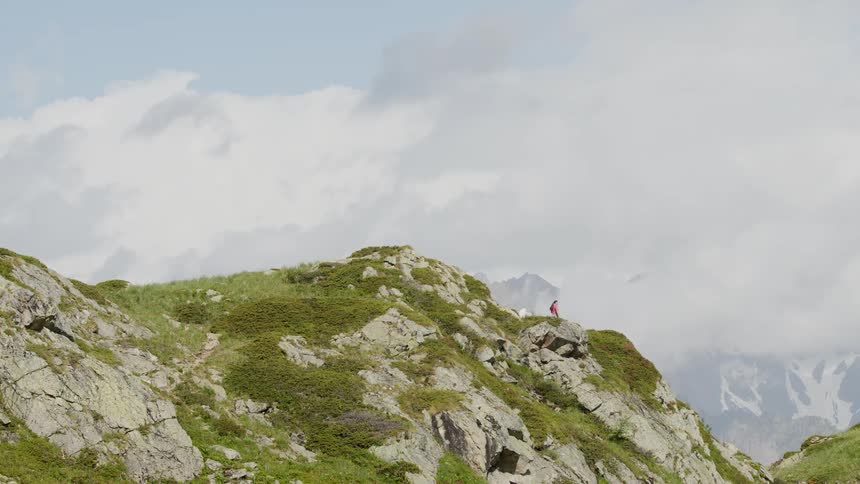 A person is hiking across the mountain during spring