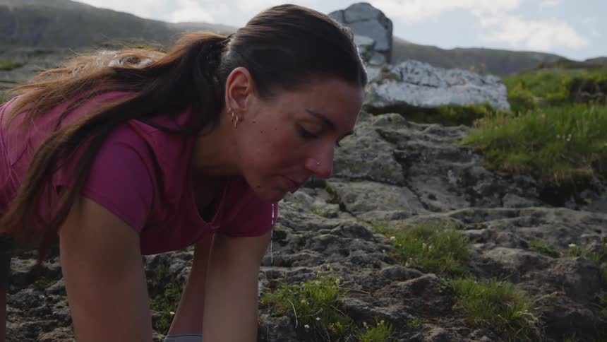A woman out in the wilderness splashes water over her face