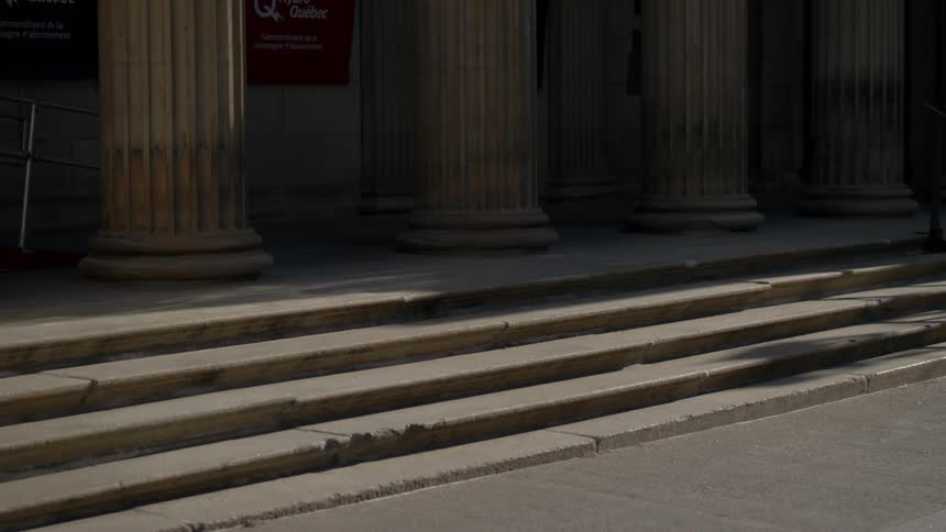A few steps lead up to a building that has numerous columns lining its entrance