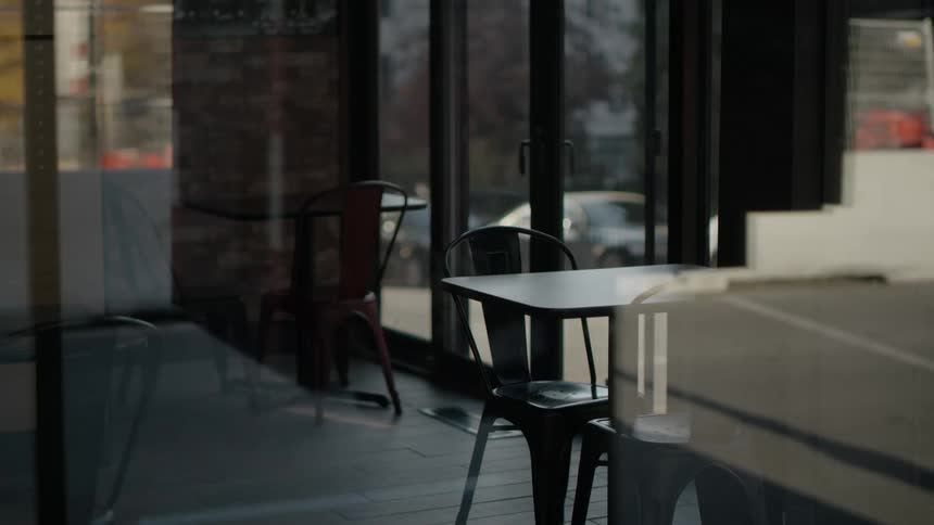 A restaurant is dark and empty as a student walks past