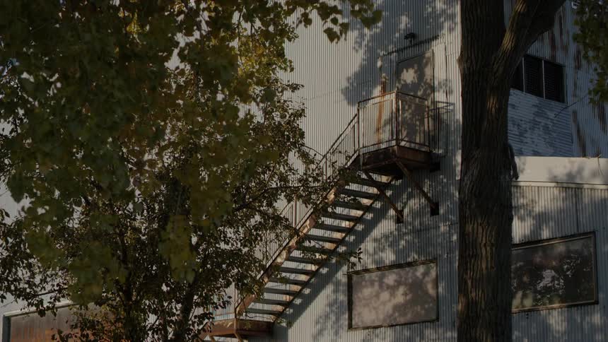 A metal staircase on the outside of an old building during the day