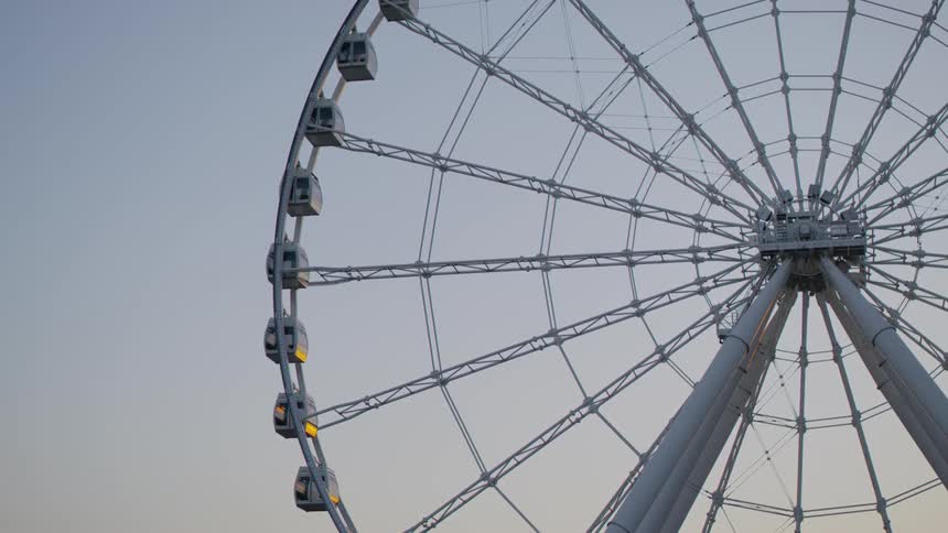 A non operating ferris wheel sits tall in the sky