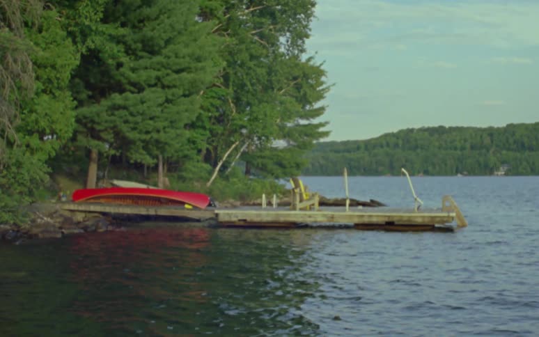 A canoe rests upside down to dry on a pier over rapid waters