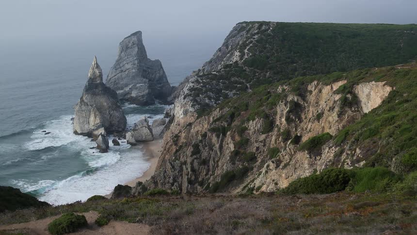 Aerial view of a beach with tall pointy rocks