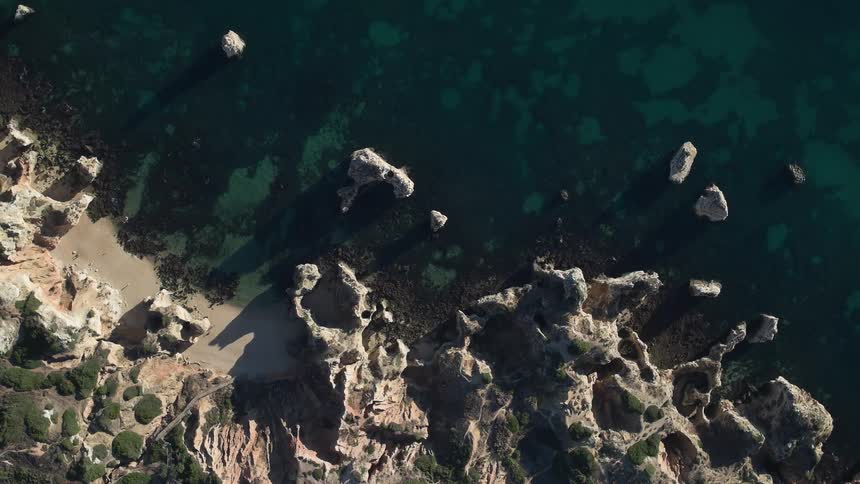 An overhead view of a rocky coastline in the daytime