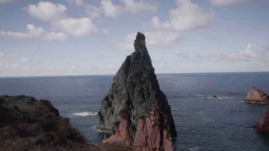 Very tall and pointy rock formation on a beach