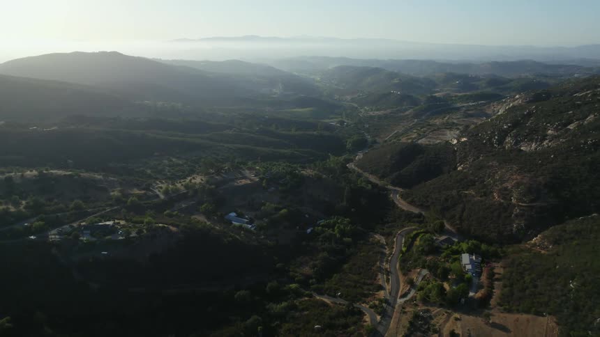 An aerial view of rural hills at sunrise