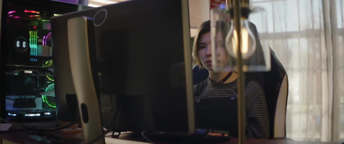 Young woman sitting in front of a gaming computer on a peaceful room