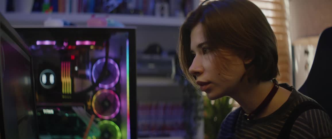A woman is sitting in front of a gaming computer
