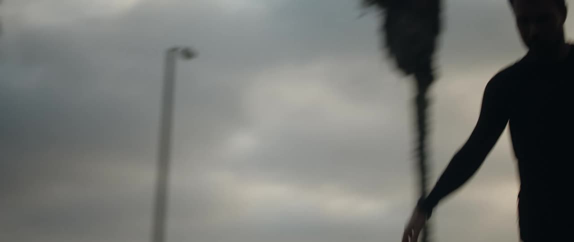 A silhouetted man kicking around a soccer ball outdoors