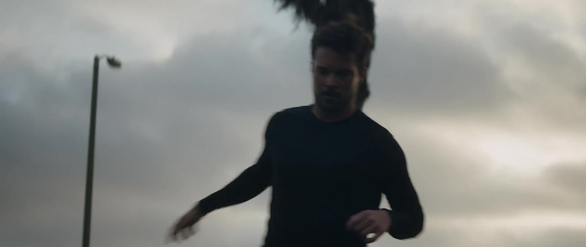 A man works out practicing footwork near palm trees