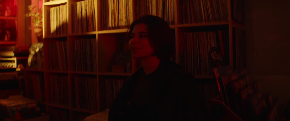 A teenage girl in a record store moves her to music