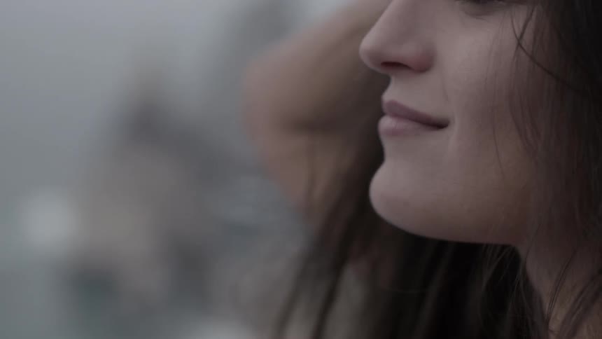 A woman softly smiles as she looks up towards the sky