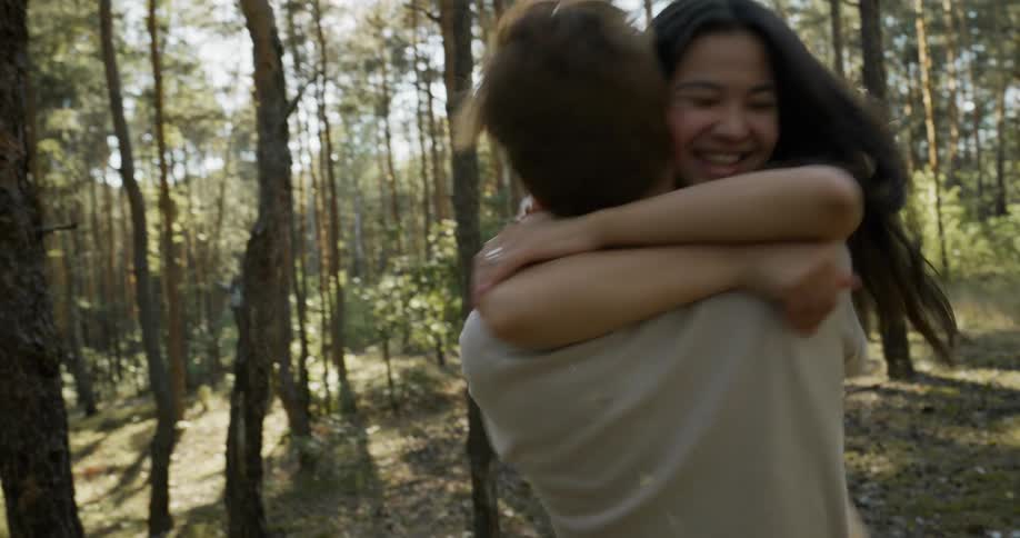 A woman runs into a mans arms and they embrace as they spin
