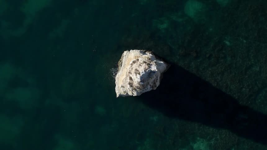 Direct overhead view of a pointy rock formation in a sea