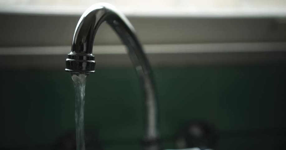 Water runs out of a kitchen faucet