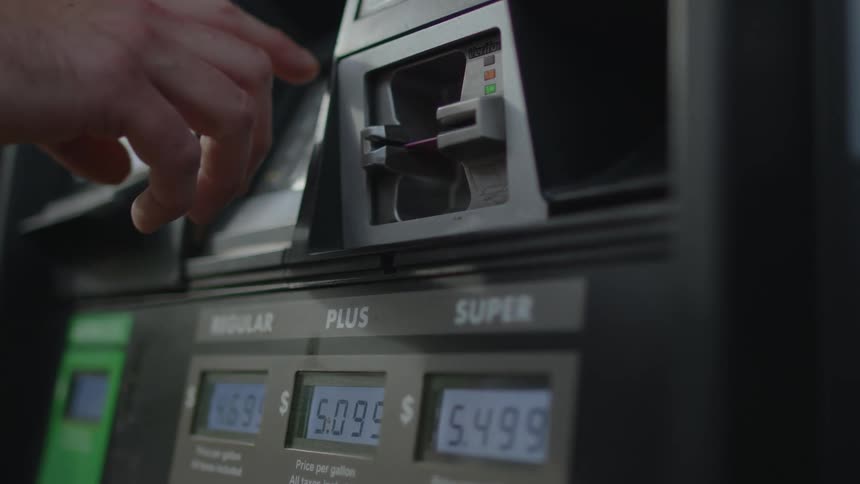 Person putting credit card into a card reader at gas pump