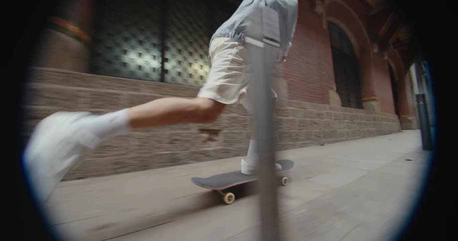 A teenage boy skateboards down a city sidewalk