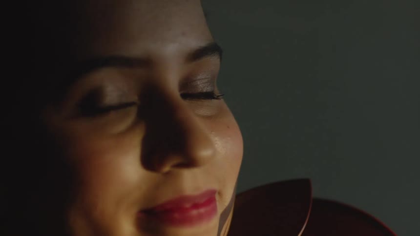 A woman is sitting indoors and smiling