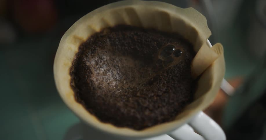 Water seeping through coffee grounds as it is being brewed at home